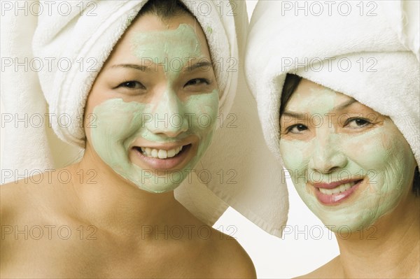 Young woman and her mother smiling for the camera in face masks