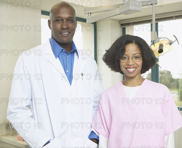 African male dentist with African female dental assistant smiling