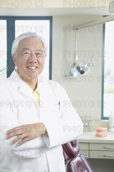 Senior Asian male dentist smiling