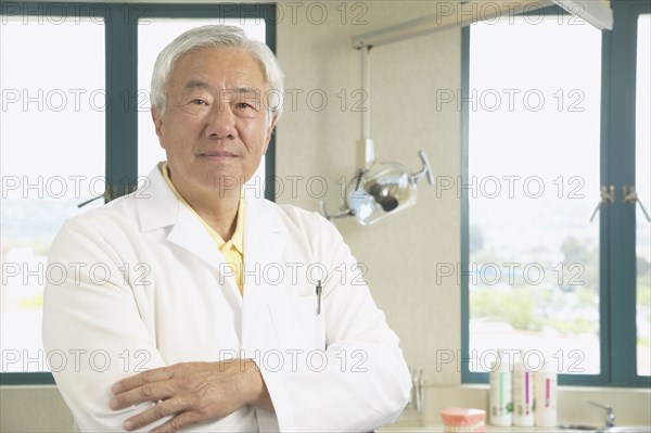 Senior Asian male dentist in office