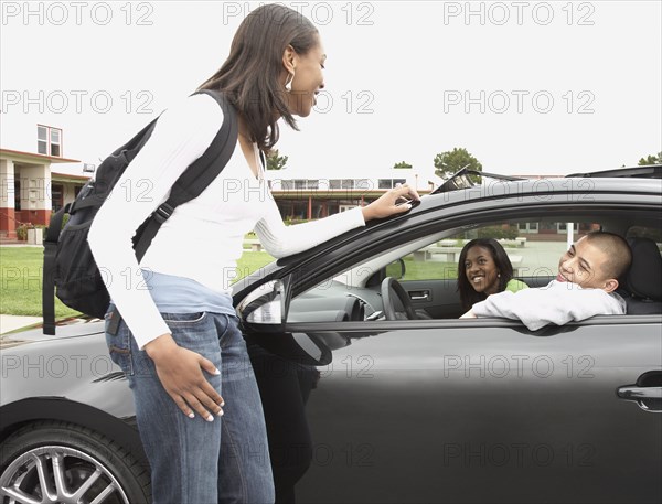 Young African woman talking to friends in car