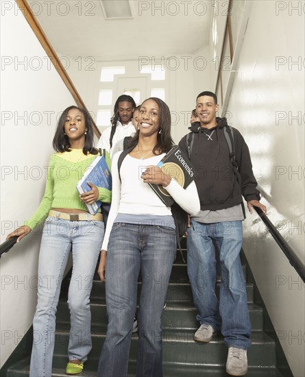 Group of African friends walking down stairs at school
