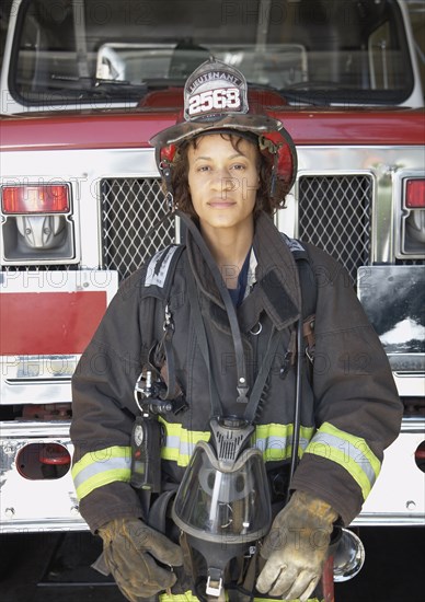 African female firefighter in front of fire truck