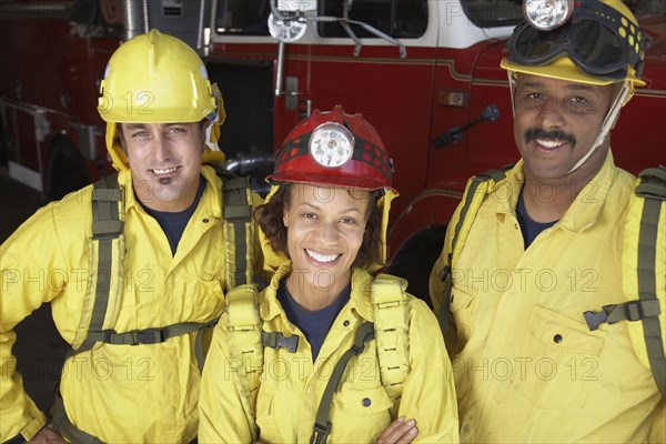 Portrait of firefighters next to fire truck