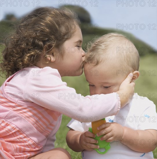 Hispanic girl kissing baby