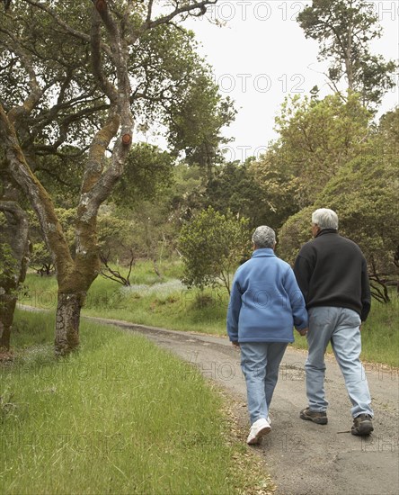 Senior couple holding hands and walking outdoors