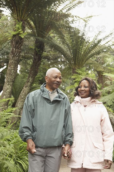 Senior African couple holding hands and walking outdoors