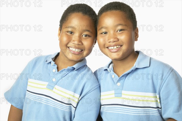 Young African twin brothers hugging and smiling