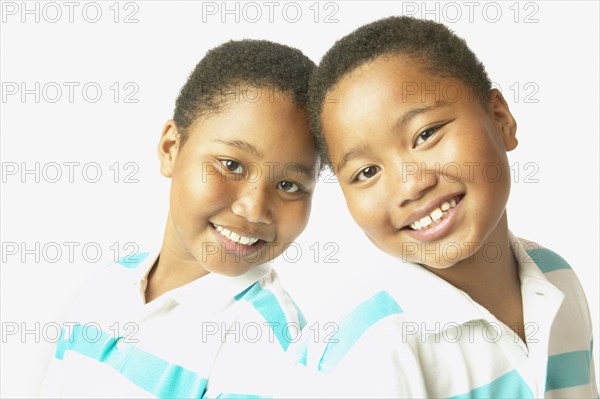 Studio shot of young African twin brothers smiling