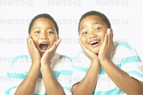 Young African twin brothers looking surprised