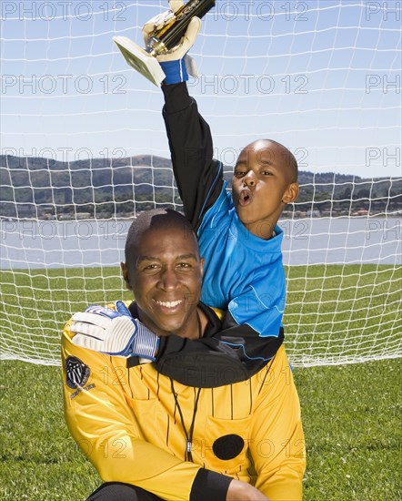 African boy and coach with soccer trophy