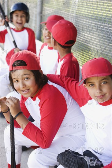 Multi-ethnic boys in baseball uniforms in dugout