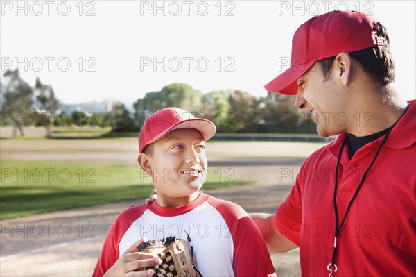 Hispanic baseball player and coach talking