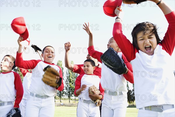 Multi-ethnic boys in baseball uniforms celebrating