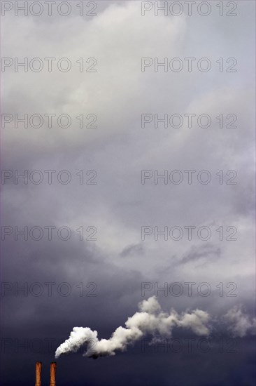 Overcast sky and smoke stacks billowing smoke