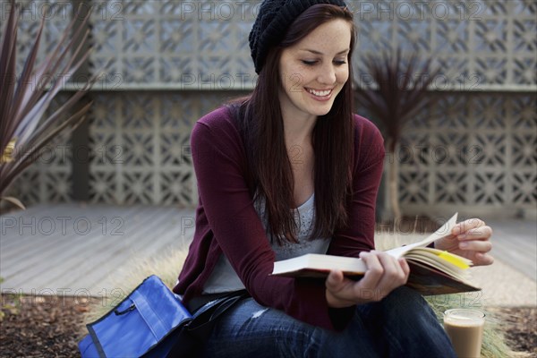 Caucasian woman reading book outdoors