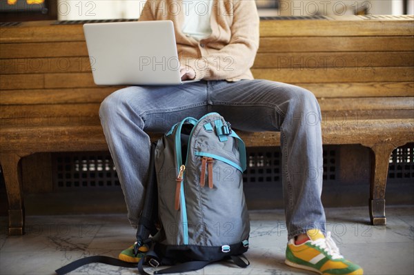 Caucasian man sitting on bench using laptop