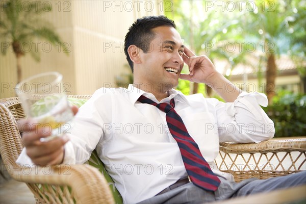 Smiling mixed race man drinking on patio