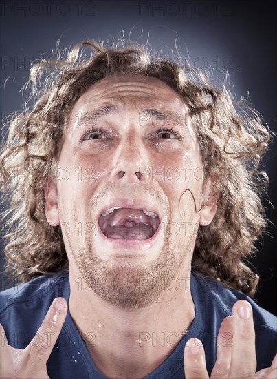 Caucasian man looking up and shouting