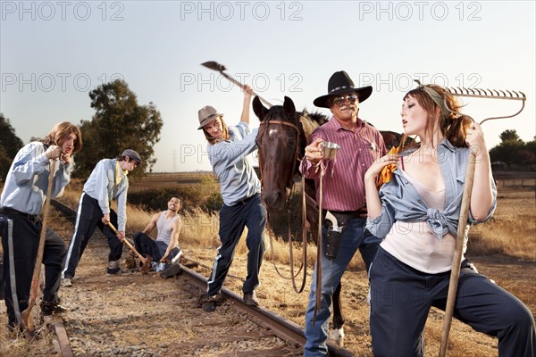 Sheriff  watching criminals working on chain gang