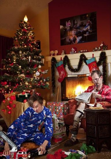 Caucasian father and son in living room on Christmas morning
