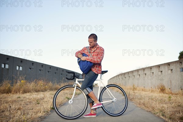 Bicycle messenger stopping on urban path