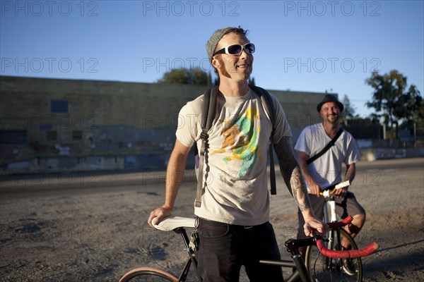 Caucasian bicycle messengers stopping on city street