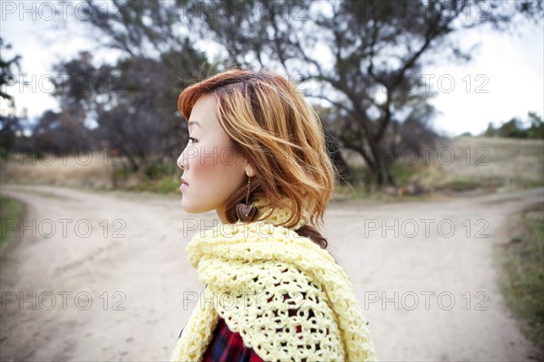 Serious Korean woman standing at fork in road