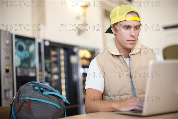 Caucasian man using laptop in train station