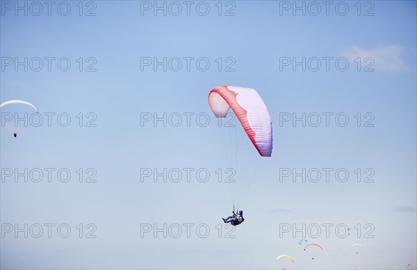 Person paragliding against blue sky