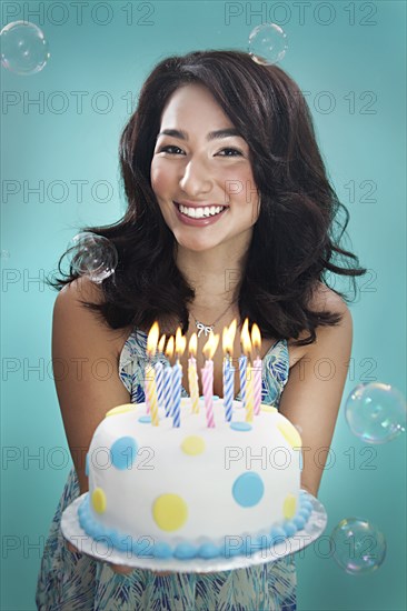 Mixed race woman holding birthday cake