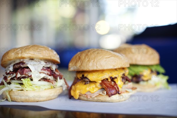 Various indulgent cheeseburgers in diner