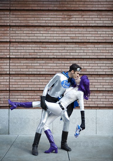 Couple in superhero costumes kissing