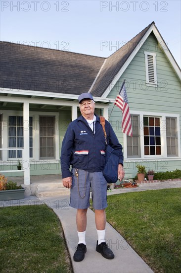 Caucasian mailman standing in front yard