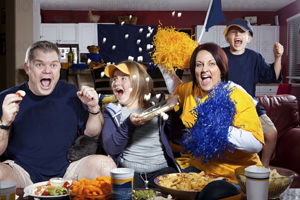 Cheering Caucasian family watching sports