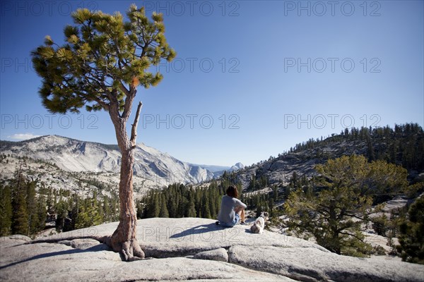 Woman and miniature schnauzer sitting in remote area