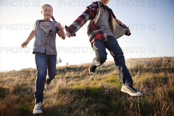 Caucasian children running in field