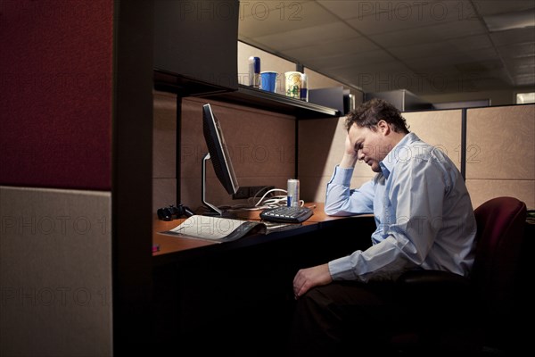 Caucasian businessman sighing at desk