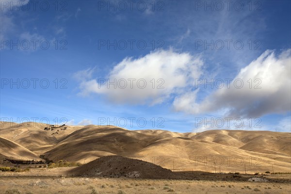 Clouds casting shadows over dry rural landscape