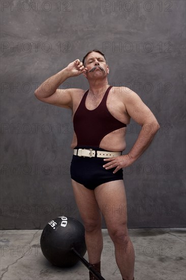 Caucasian weight lifter twirling his mustache