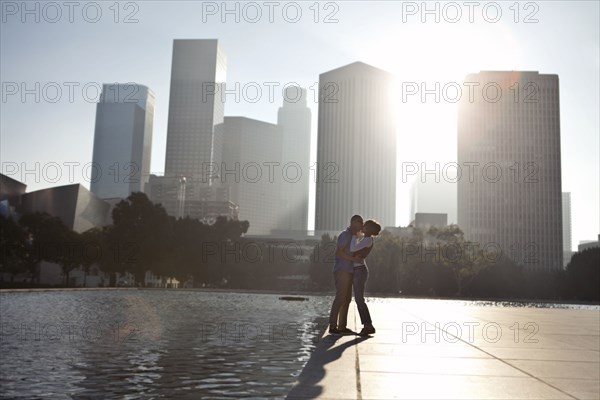 Couple kissing by urban waterfront