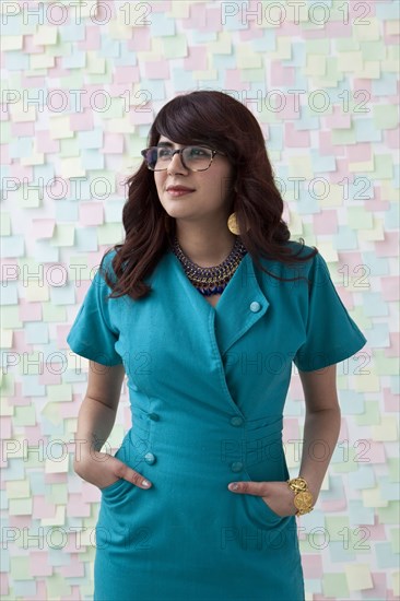 Mixed race businesswoman by wall of sticky notes