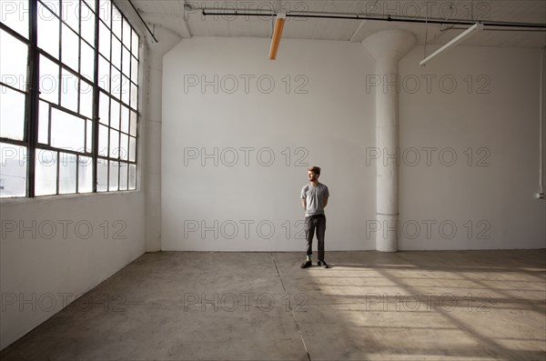 Caucasian man standing in empty loft
