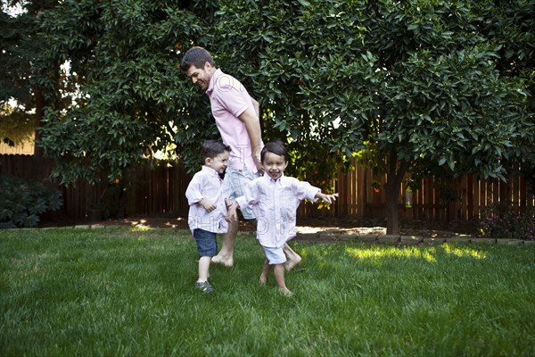 Caucasian father and sons playing in backyard