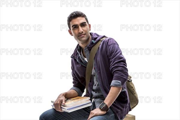 Indian student holding stack of books