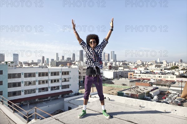 African American man and cityscape from urban rooftop