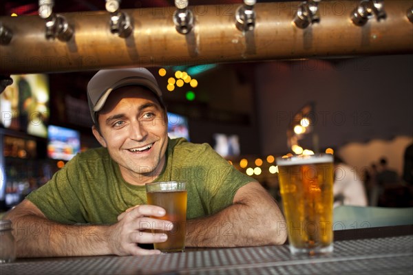 Caucasian man drinking beer in bar