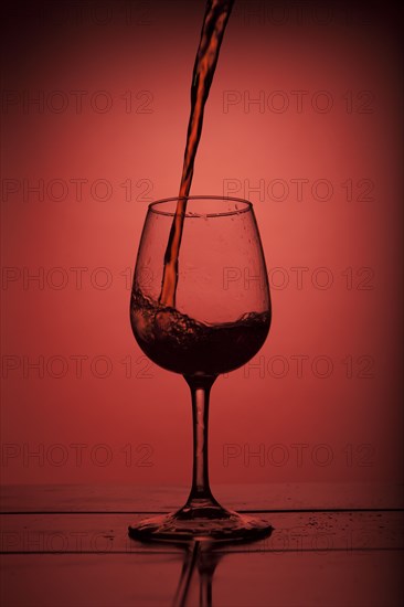 Red wine pouring into wine glass