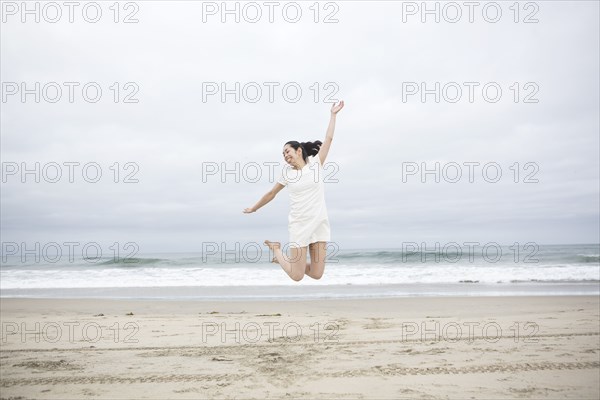 Woman jumping for joy on beach