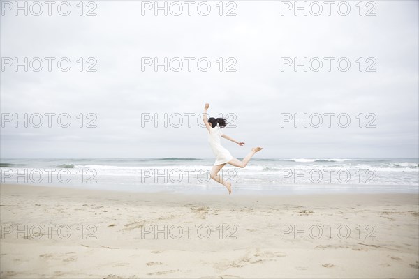 Woman jumping for joy on beach